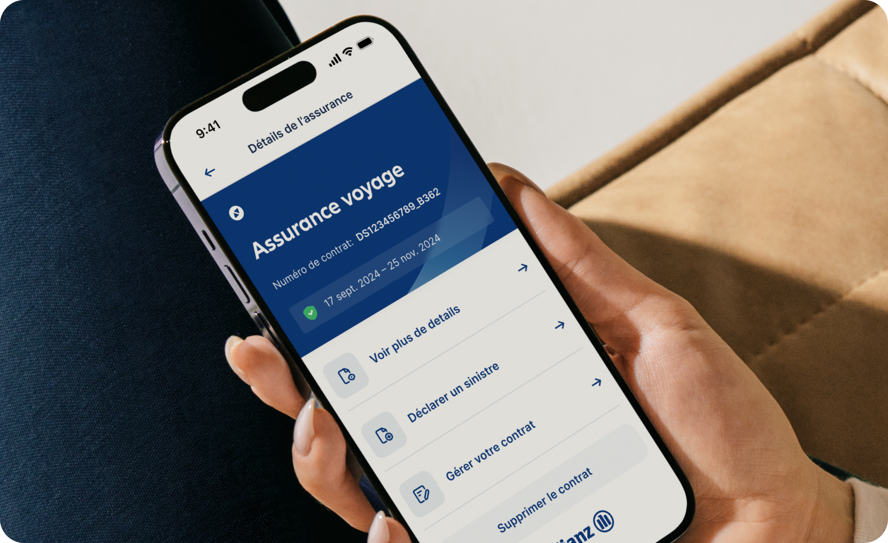 Une image de la main d'une femme tenant un smartphone avec les détails de la police d'assurance voyage Allyz.